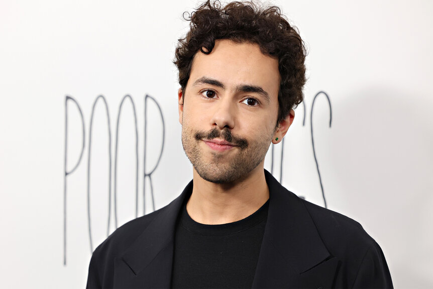 Ramy Youssef wears a black shirt and jacket to the "Poor Things" premiere at DGA Theater