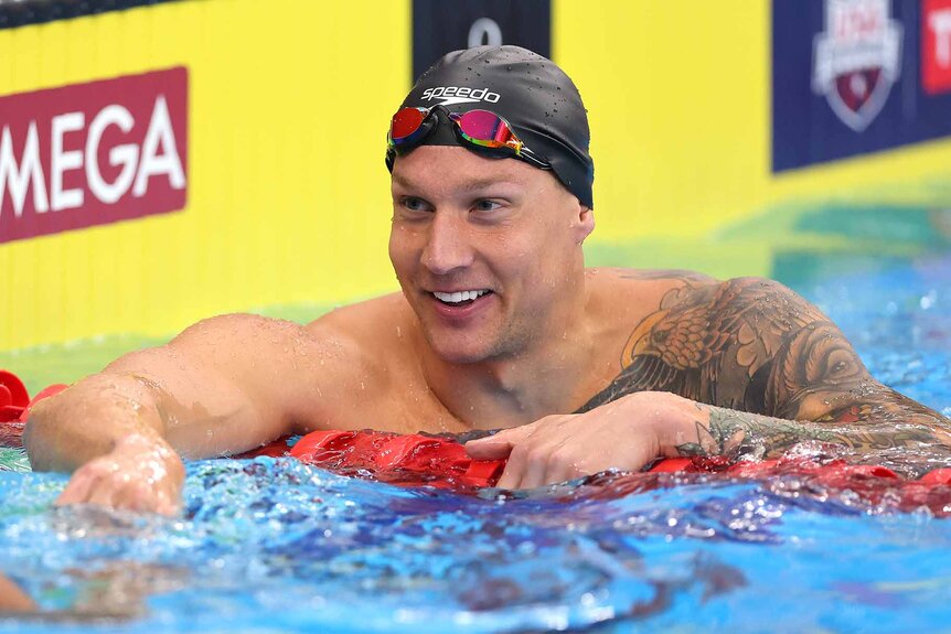 Caeleb Dressel smiles in the pool.