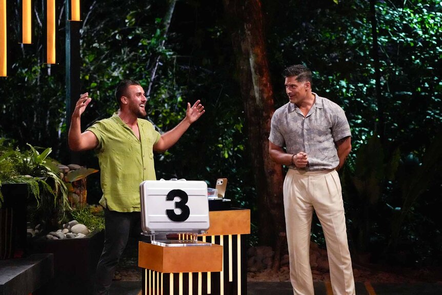 Dawson Addis raises his arms and smiles at Joe Manganiello in Deal or No Deal Island Episode 108.