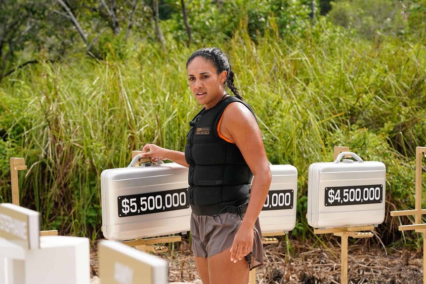 Jordan Fowler touches a briefcase in Deal or No Deal Island Episode 110.