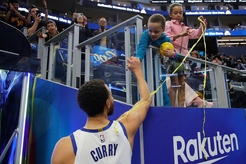 Steph Curry is congratulated by his son Canon as his daughter Riley looks on after winning a game