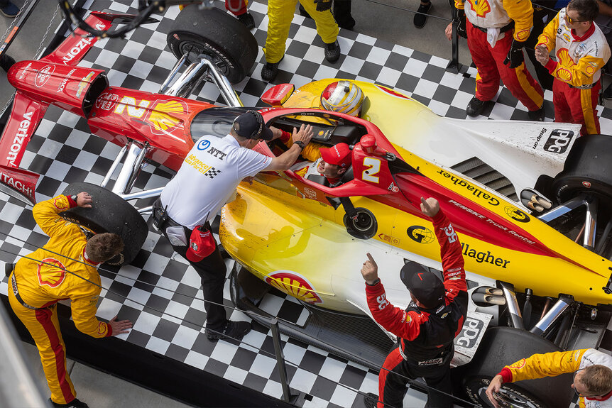 Josef Newgarden being high fived by team members on Victory Lane