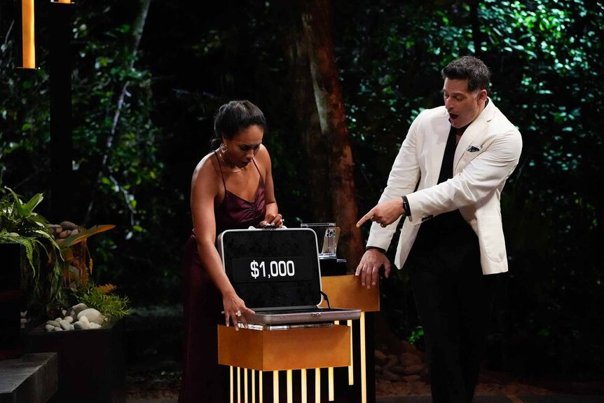 Jordan Fowler opens a $1000 briefcase as Joe Manganiello points on Deal or No Deal Episode 112.