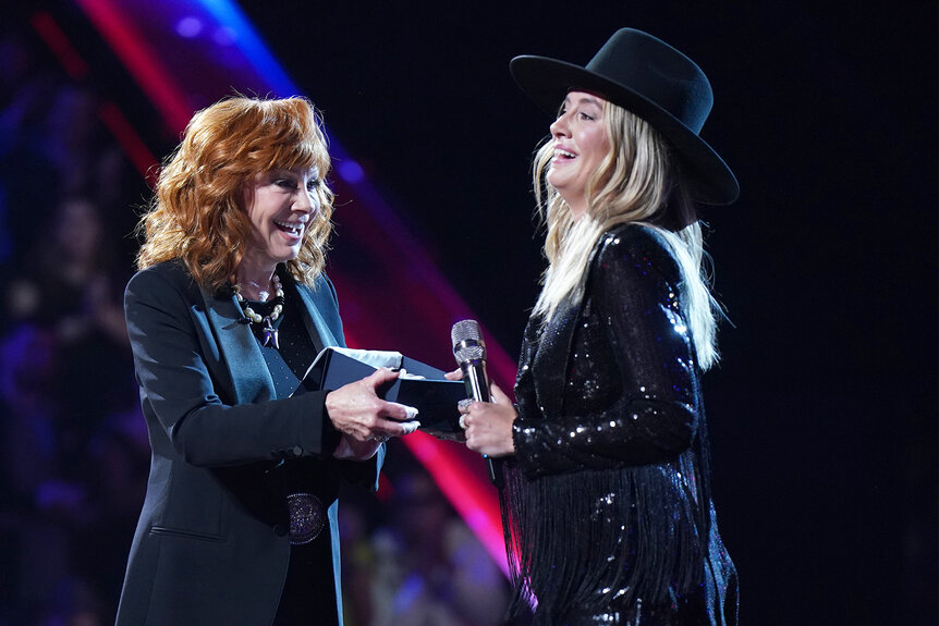 Reba Mcentire hands Lainey Wilson a belt buckle on The Voice episode 2517B