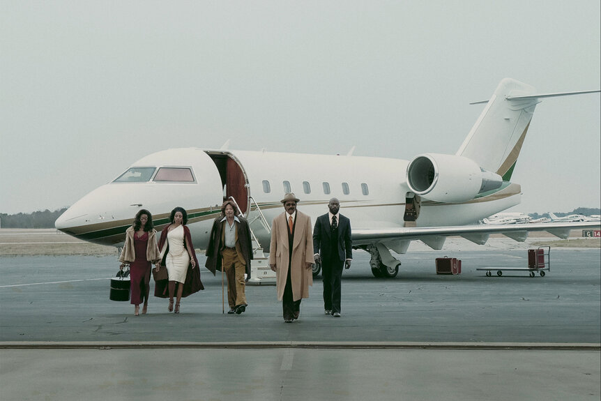 the cast of Fight Night The Million Dollar Heist walk on a tarmac in Episode 101