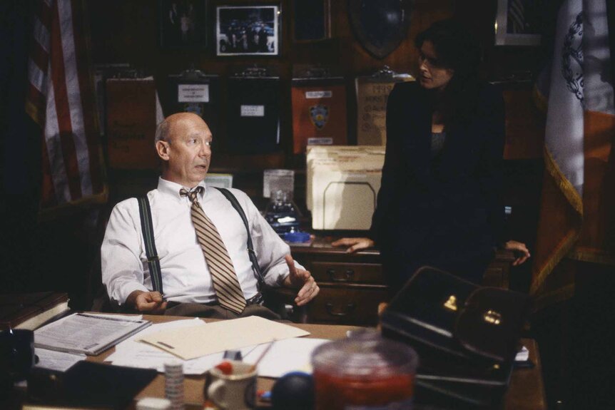 Captain Donald Cragen and A.D.A. Abbie Carmichael speak at a desk in Law & Order: Special Victims Unit Episode 106.