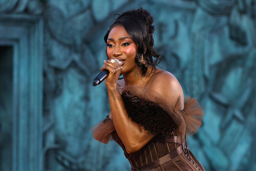 Aya Nakamura performs during Vogue World: Paris in a brown dress