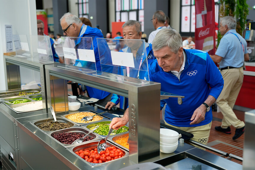 IOC President Thomas Bach gets Food at the salad bar at the Paris Olympics