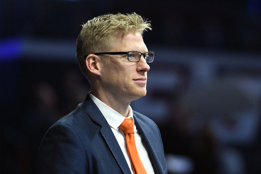 Justin Spring looks on wearing an orange tie during the mens Gymnastics Championship