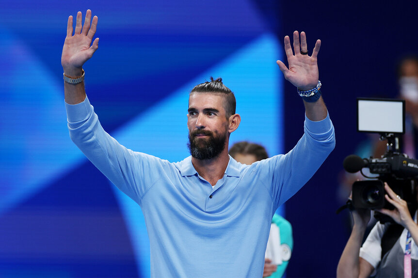 Michael Phelps waves to the crowd at the 2024 olympics