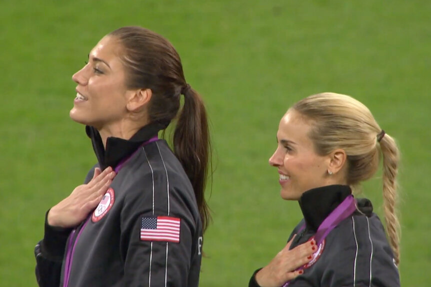 Alex Morgan and her teammate sing the national anthem during the Rio 2016 Olympic Games