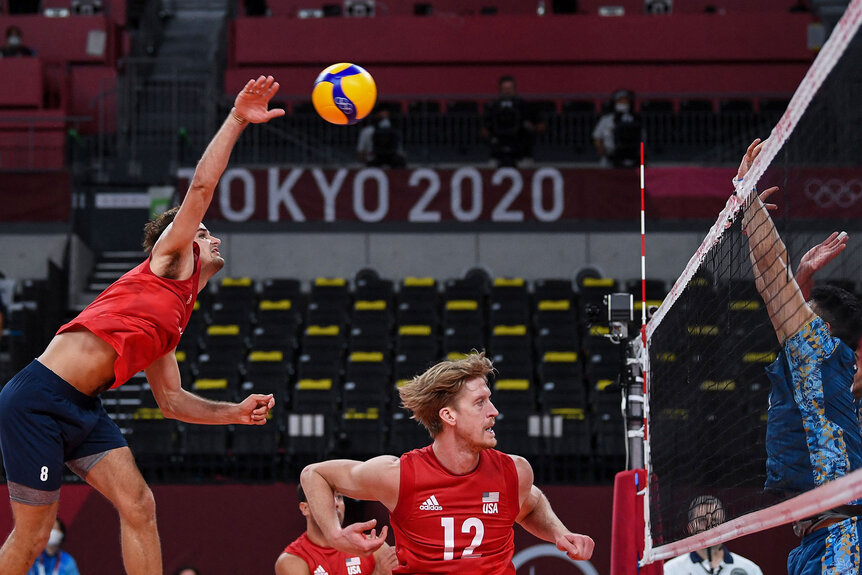 USA's Torey Defalco (L) spikes the ball in the men's preliminary round pool B volleyball match between USA and Argentina in Tokyo