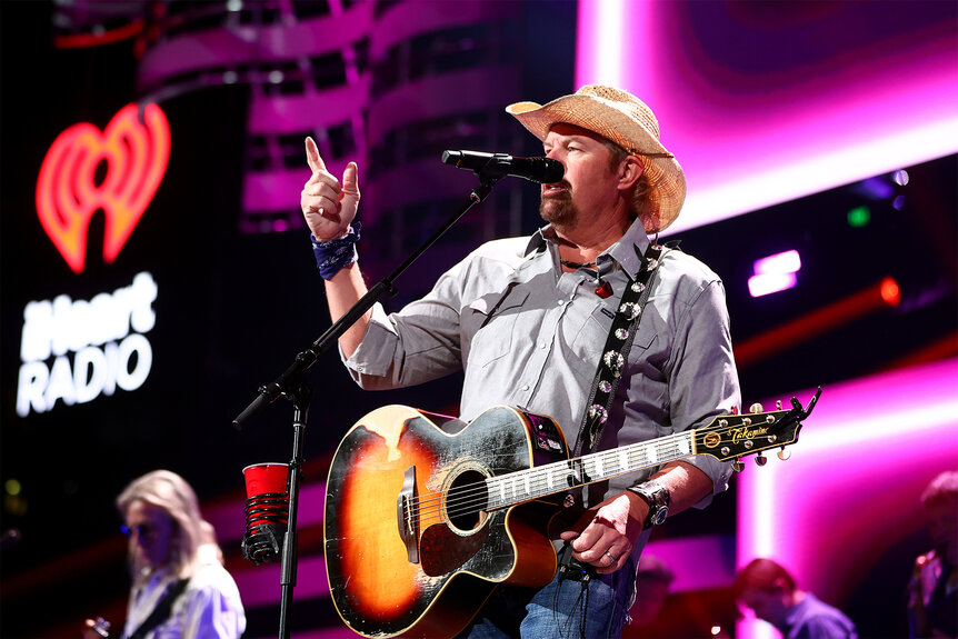 Toby Keith performs on stage in a cowboy hat in 2021