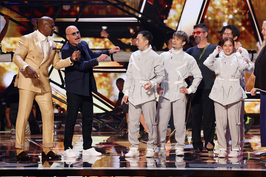 Airfootworks celebrates on stage with Terry Crews and Howie Mandel after getting a golden buzzer