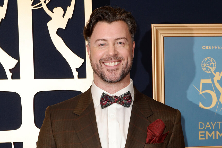 Daniel Feuerriegel wears a dark red tuxedo on the red carpet at the daytime emmys