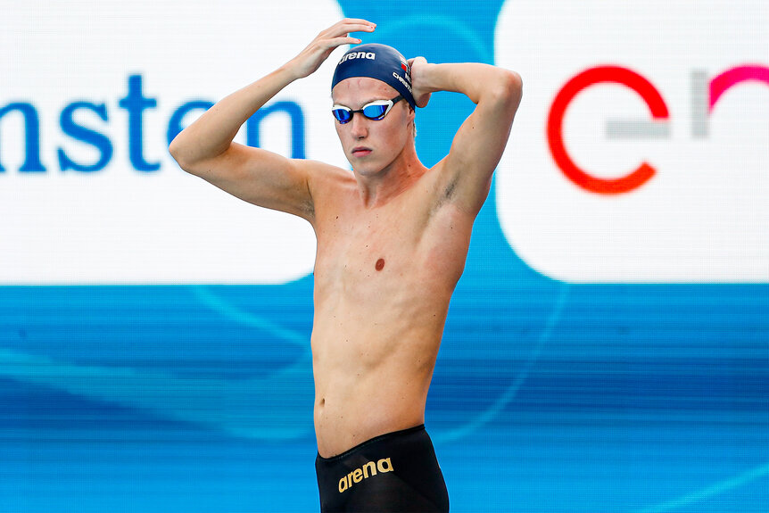 Henrik Christiansen fixes his swim cap during a swim meet