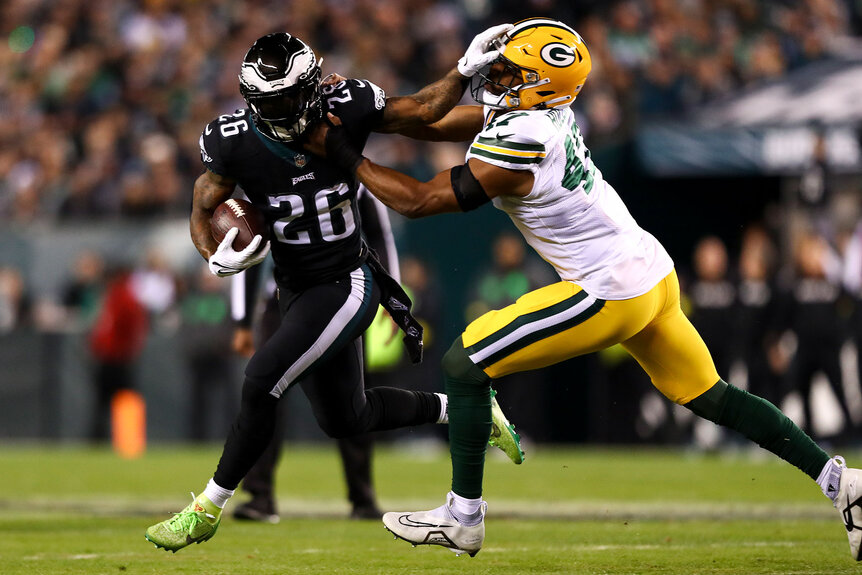 Miles Sanders #26 of the Philadelphia Eagles stiff arms Justin Hollins #47 of the Green Bay Packers during the first quarter of an NFL football game