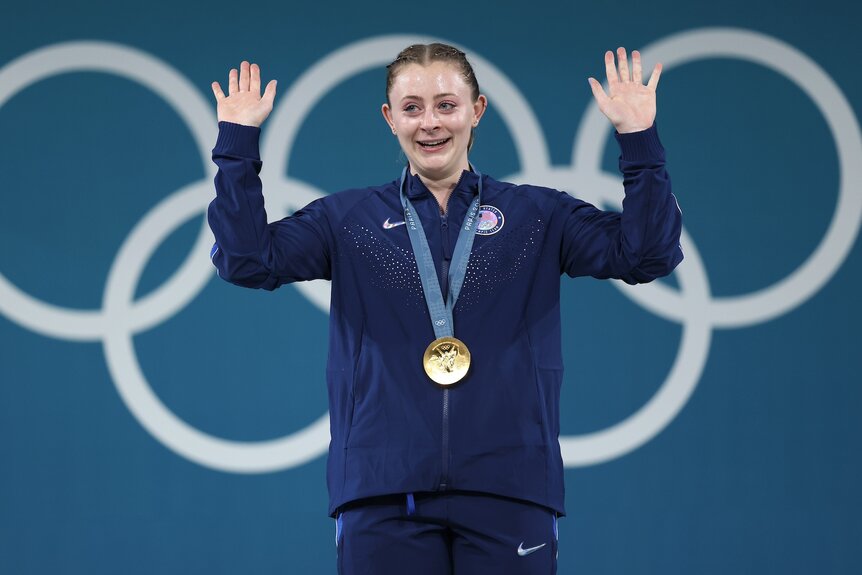 Olivia Reeves waves after receiving her gold medal in weightlifting at the 2024 Olympics