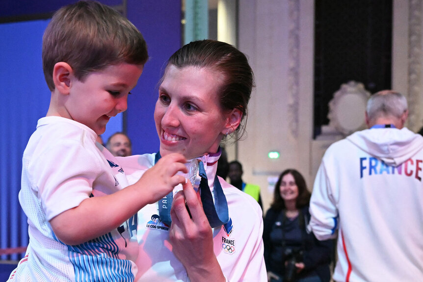 Silver medallist France's Auriane Mallo-Breton holds her son Mathis after the medal ceremony for the women's epee individual competition during the Paris 2024 Olympic Games