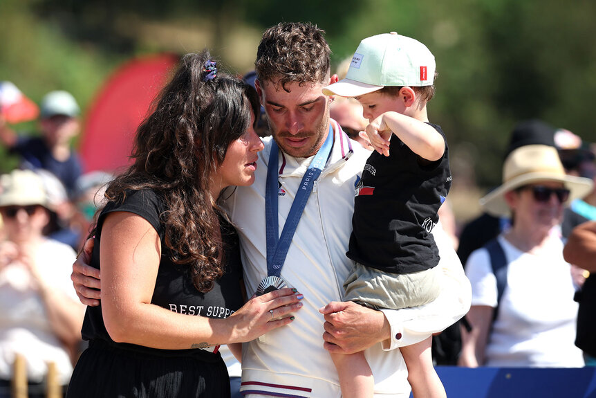 Silver medalist Victor Koretzky of Team France (C) poses for a photograph with his wife Lea (L) and his son (R) during the Men's Cross-Country on day three of the Olympic Games Paris 2024