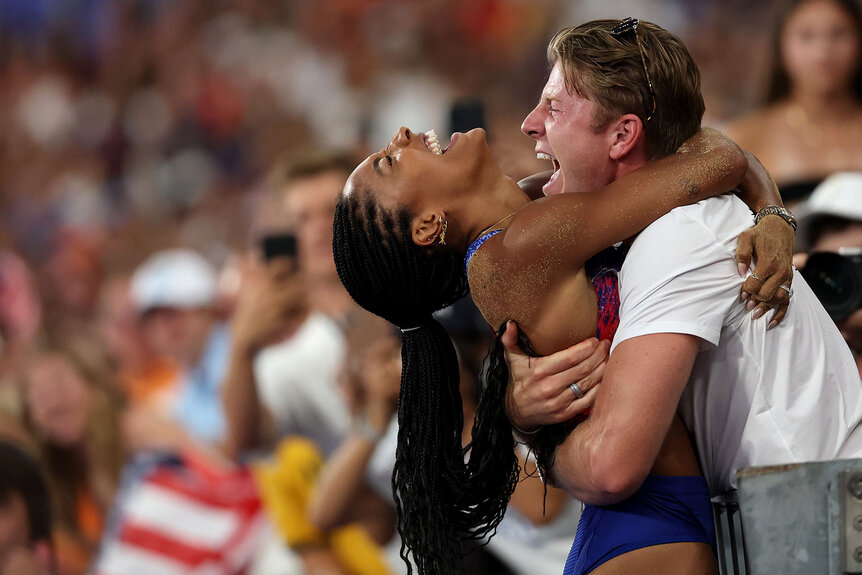 Tara Davis-Woodhall of Team United States celebrates with her husband Hunter Woodhall after winning the gold medal in the Women's Long Jump Final at the Paris 2024 Olympics