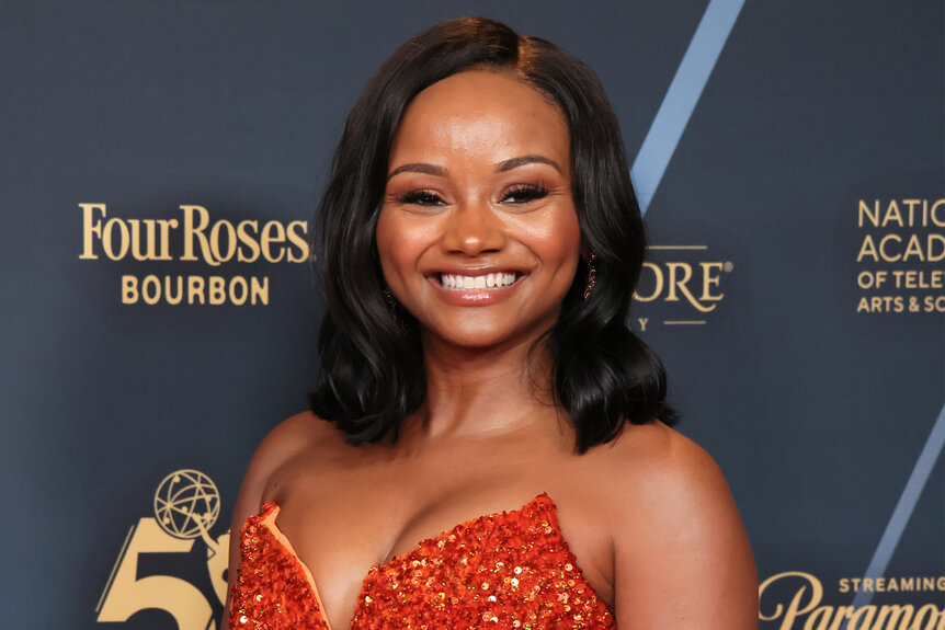 Raven Bowens wears a red sequin gown on the red carpet at the daytime emmy awards