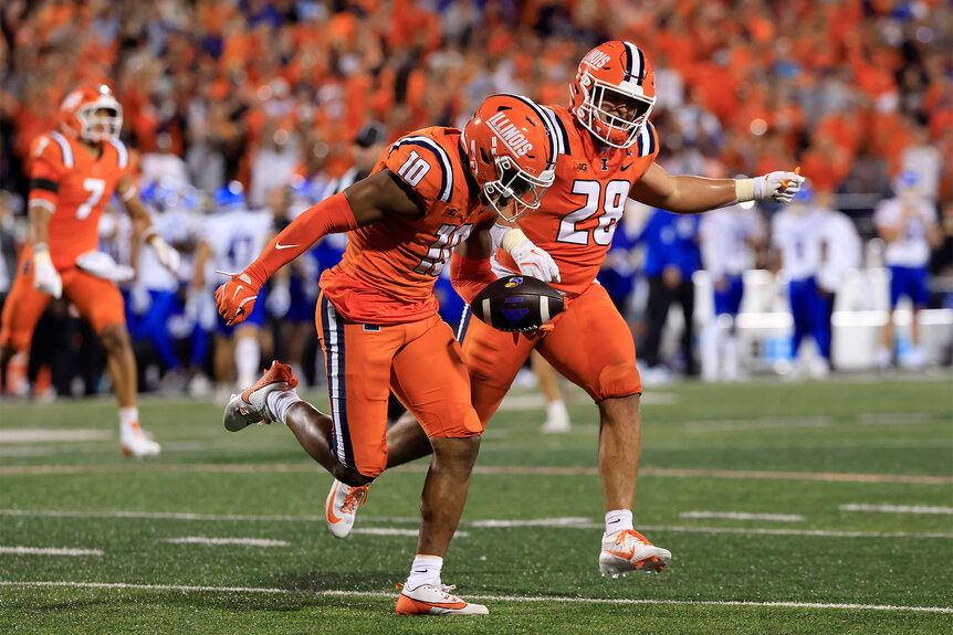 Fighting Illini players celebrate after a play on the football field