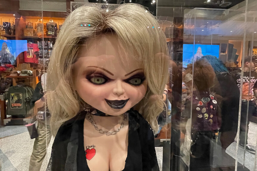 A doll from chucky in a glass case in the universal studio store