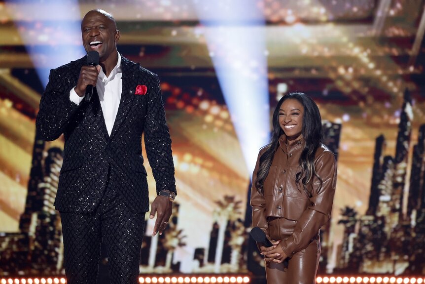 Terry Crews and Simone Biles stand onstage on America's Got Talent Episode 1920.