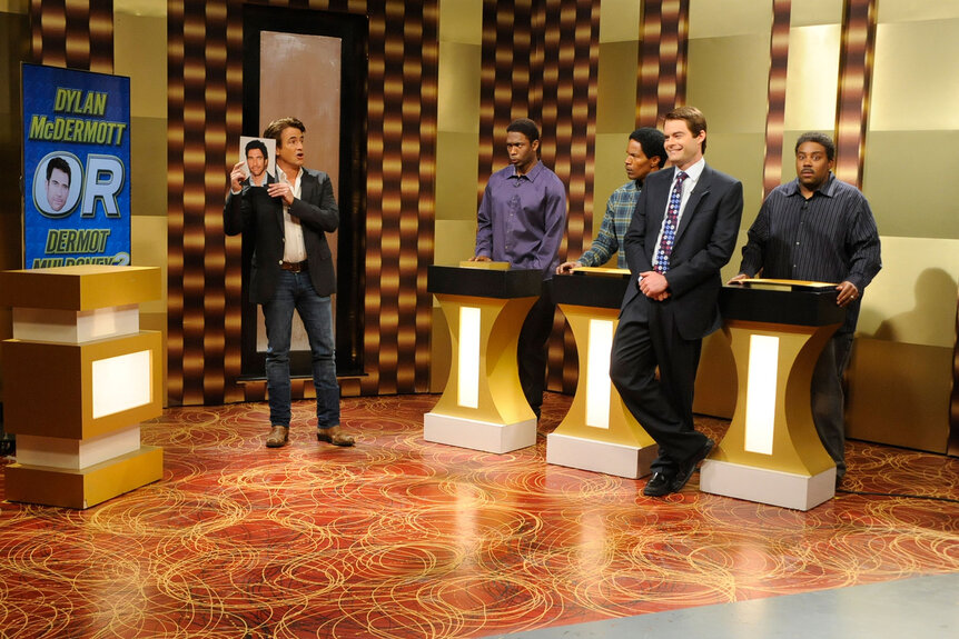 Dermot Mulroney, Jay Pharoah, Jamie Foxx, Bill Hader, and Kenan Thompson stand on a game show set suring an SNL skit