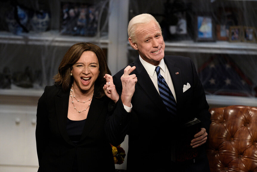 Maya Rudolph as Kamala Harris and Jim Carrey as Joe Biden twisting their fingers together