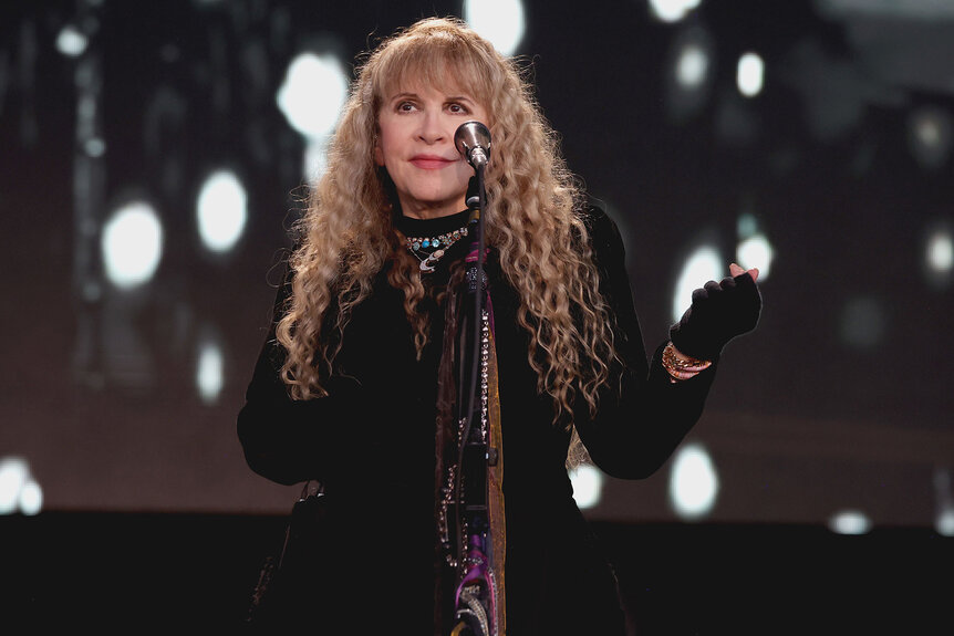 Stevie Nicks performs on stage in a black dress