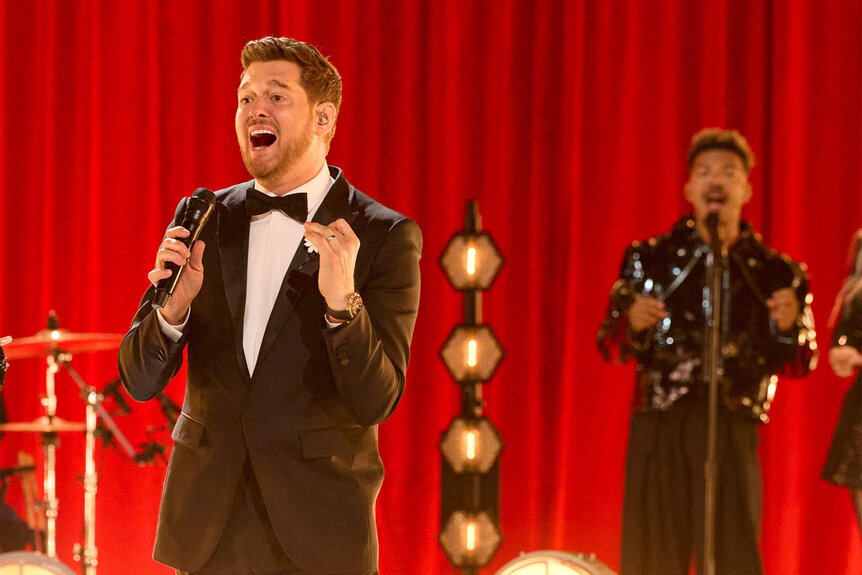 Michael Bublé performs in front of a red curtain