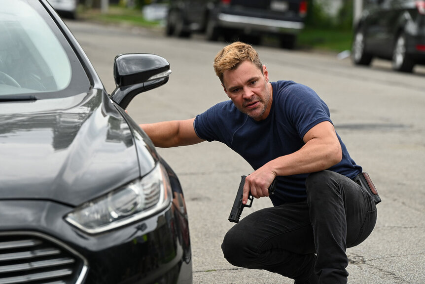 Officer Adam Ruzek (Patrick John Flueger) ducks behind a car