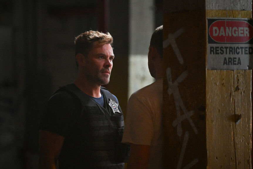 Officer Adam Ruzek (Patrick John Flueger) interrogates a man against a wall