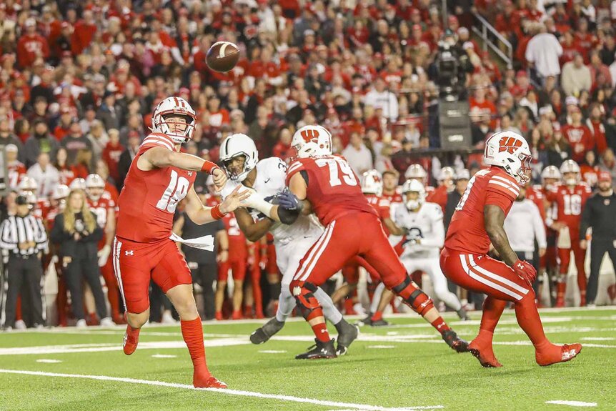 Wisconsin quarterback Braedyn Locke (18) makes a throw during a football game.