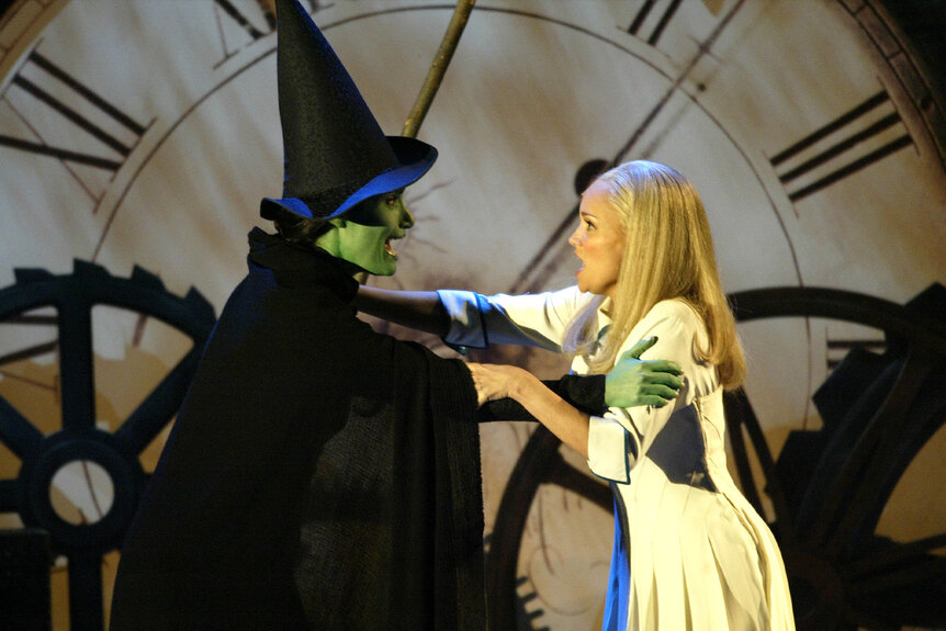 Elphaba (Idina Menzel) and Glenda (Kristin Chenoweth) hold each other and perform in Wicked.