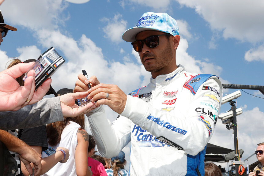 Kyle Larson signs autographs for fans prior to the running of the NASCAR Cup Series YellaWood 500