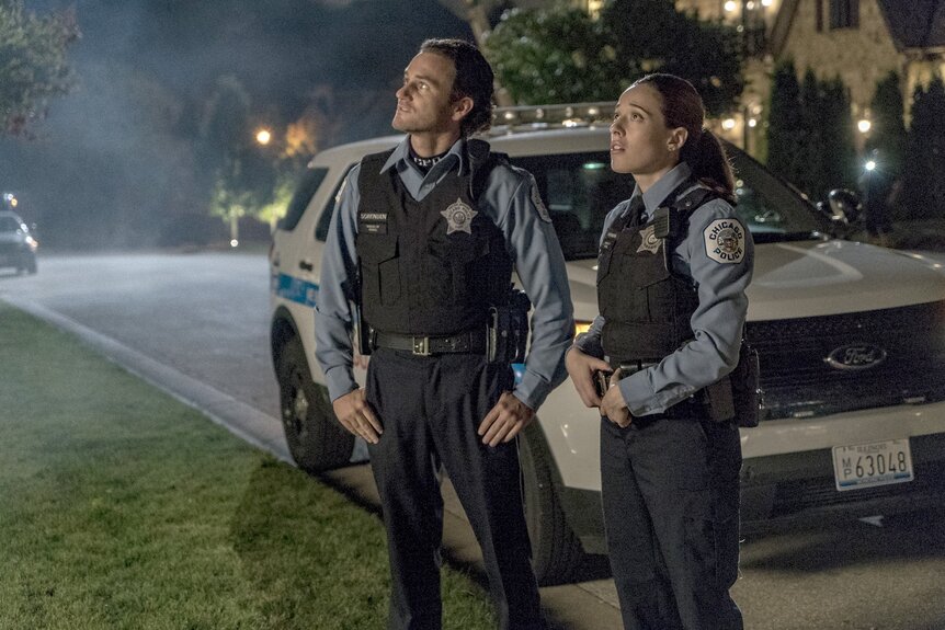 Craig "Mouse" Gurwitch (Samuel Hunt) and Kim Burgess (Marina Squerciati) stand outside in police uniforms in Chicago P.D. Episode 406.