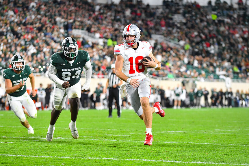 Ohio State Buckeyes quarterback Will Howard (18) sprints toward the end zone during a college football game