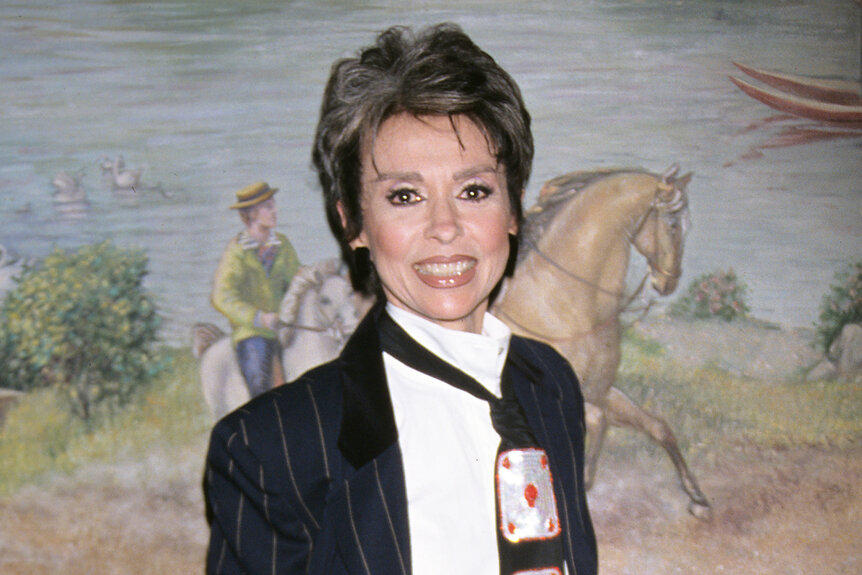 Rita Moreno wears a black and white suit with playing cards on it