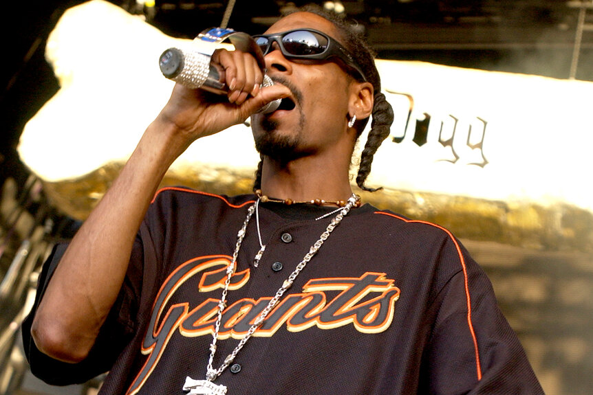 Snoop Dogg wears a giants t-shirt on stage while performing