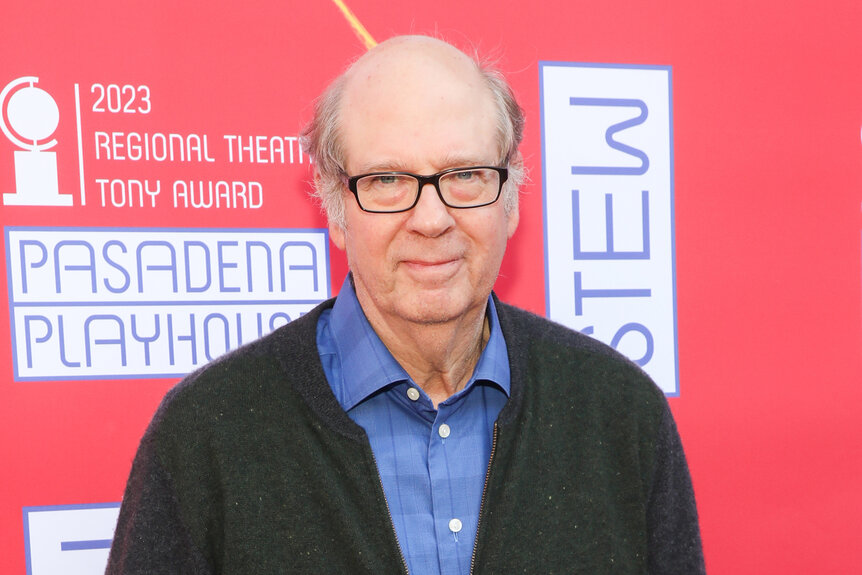 Stephen Tobolowsky wears a sweater and blue shirt on the red carpet