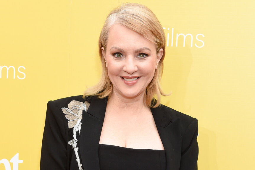 Wendi Mclendon-Covey smiles in a black dress on the red carpet