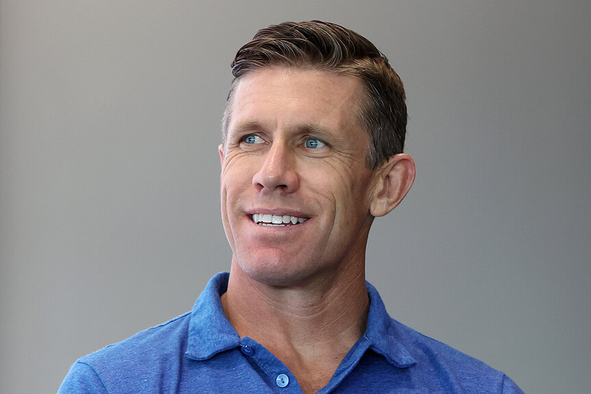 Carl Edwards wears a blue shirt and looks to the side smiling