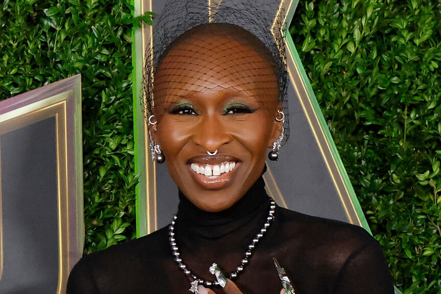 Cynthia Erivo smiling and laughing in front of a step and repeat.