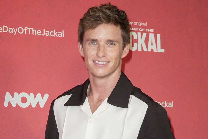 Eddie Redmayne wears a black and white shirt on the red carpet