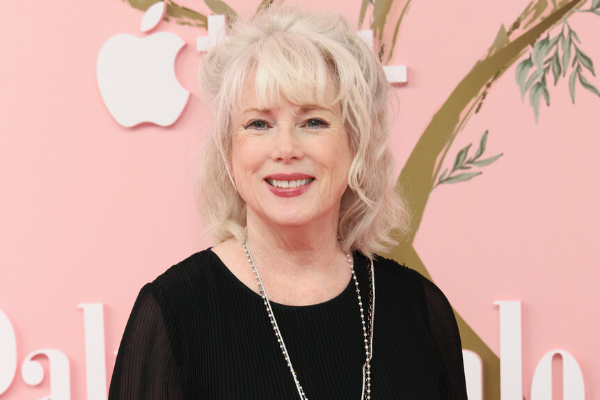 Julia Duffy smiles in a black shirt on the red carpet