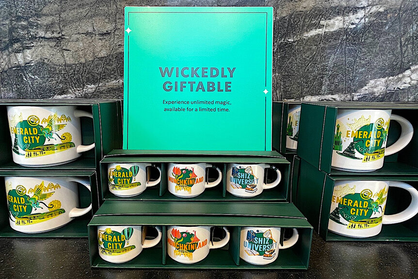 A variety of coffee mugs featuring wicked locations in a store in Universal Studios Hollywood