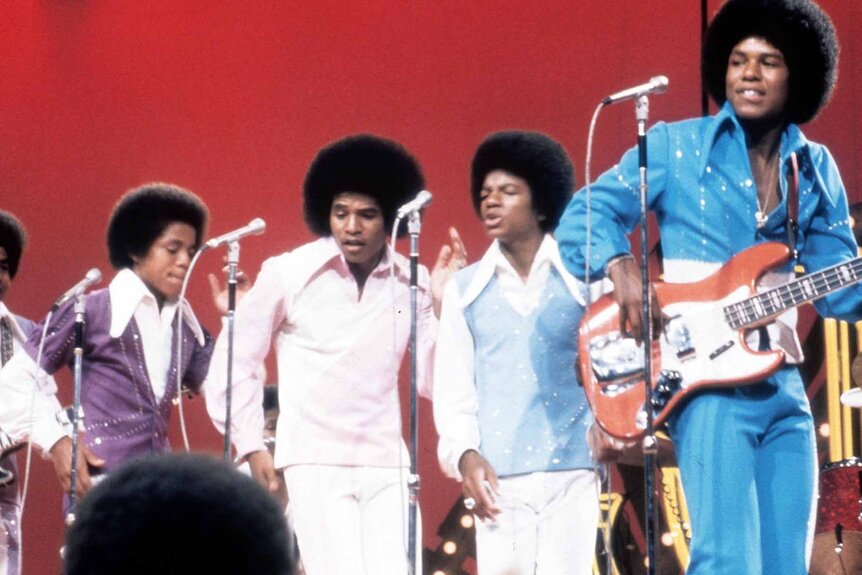 The Jackson 5 perform with matching afros in a line.